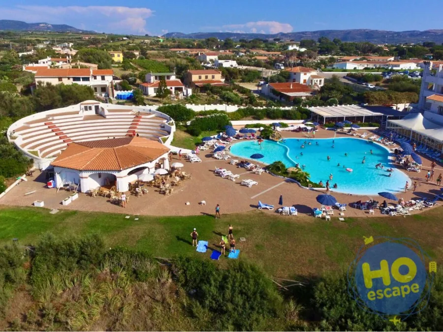Veduta aerea della piscina con bagnanti e anfiteatro del resort