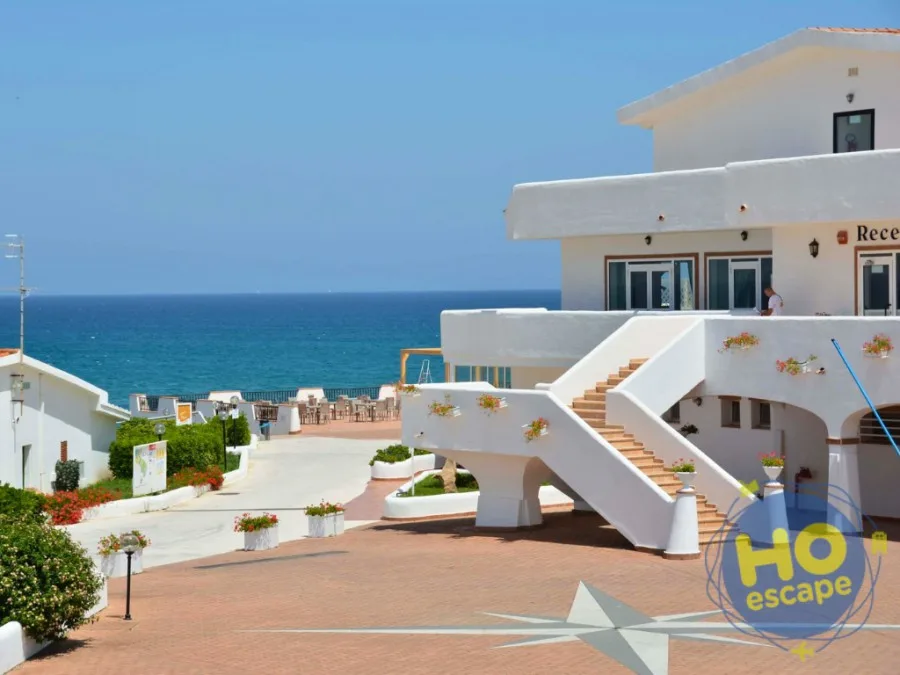 Reception del resort con scalinata bianca e terrazza affacciata sul mare