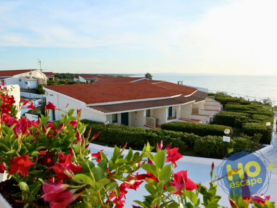 Veduta esterna delle ville con tetti rossi e giardini affacciati sul mare