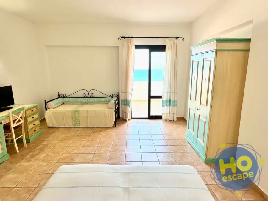 Camera con divano letto, armadio e porta finestra con vista mare