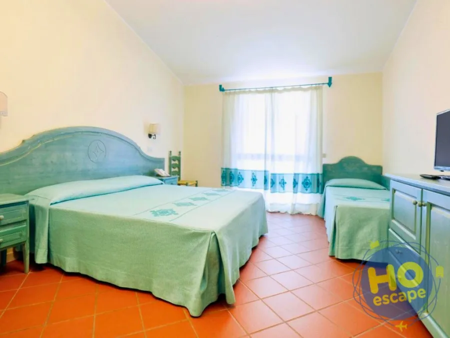 Camera matrimoniale con letto aggiunto, arredi in legno azzurro e pavimento in cotto