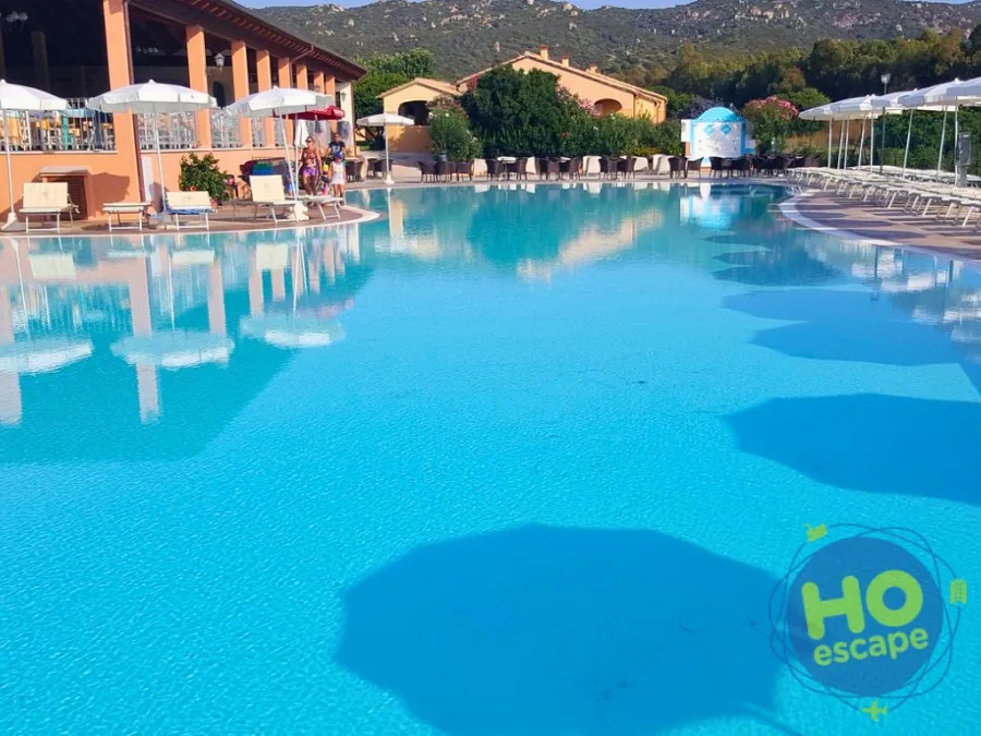 Piscina del resort con area bar e ombrelloni