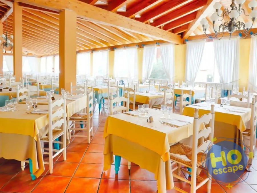 Sala ristorante interna con tovaglie gialle e sedie bianche