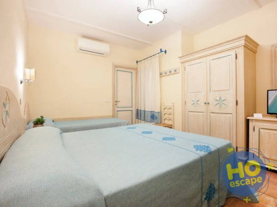 Camera con letto matrimoniale e letto singolo, arredi in legno chiaro