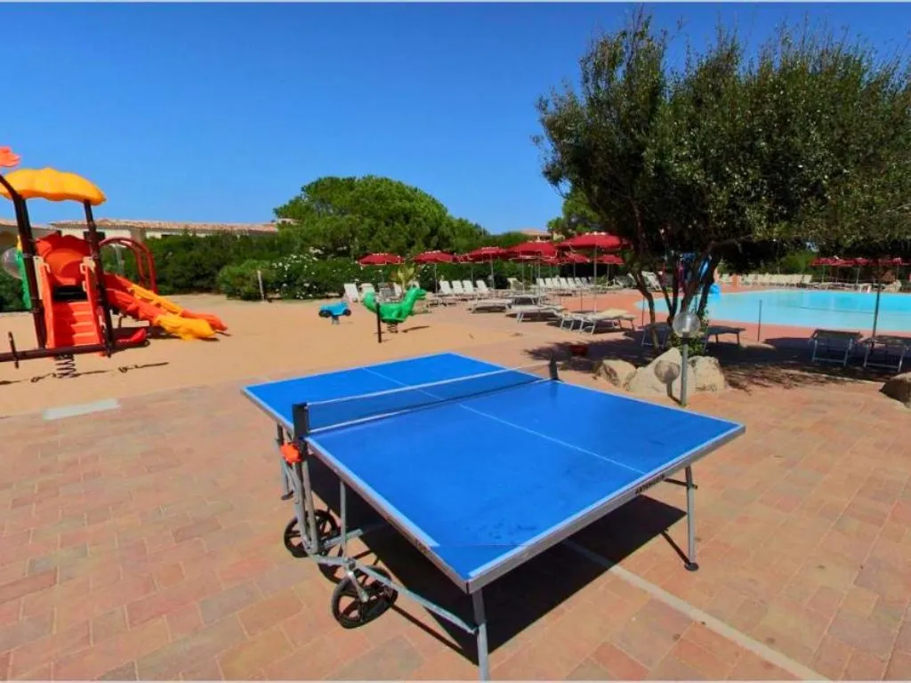 Tavolo da ping pong vicino alla piscina e area giochi per bambini