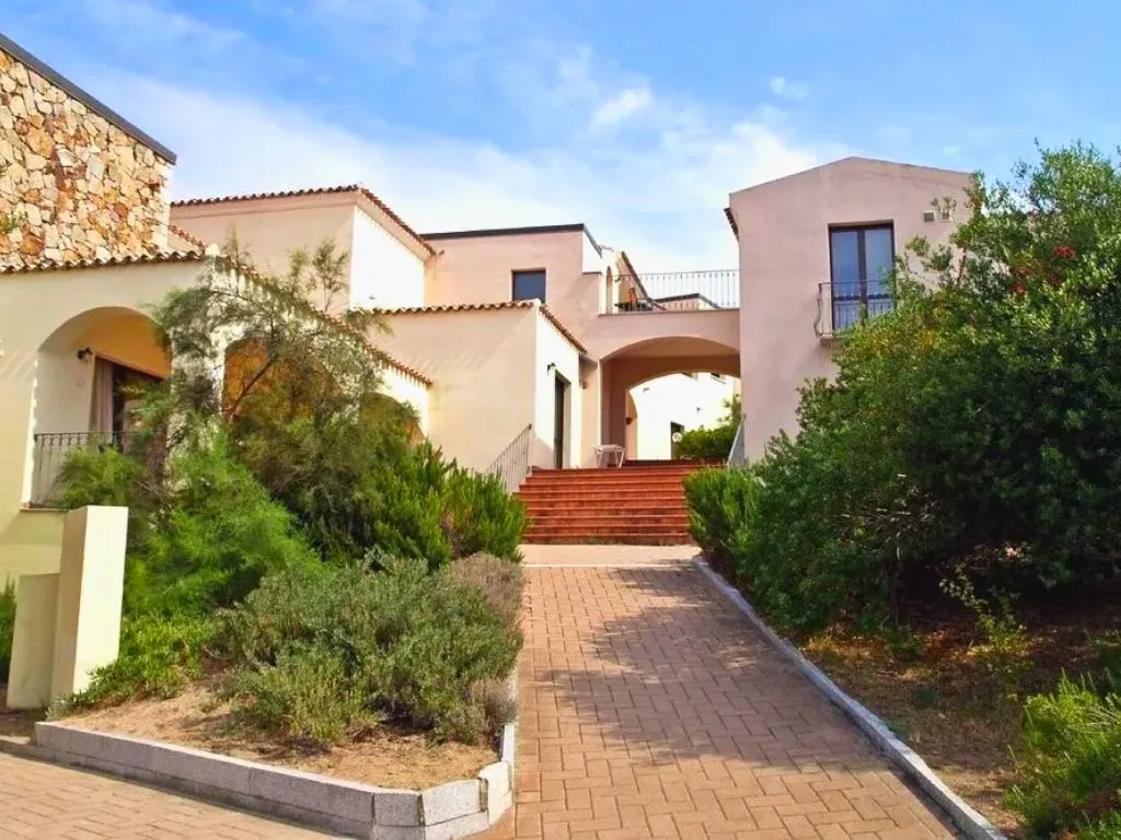 Edifici del residence con scalinata in mattoni e giardino mediterraneo