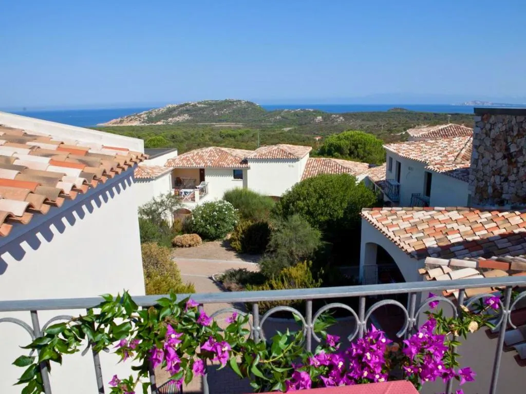 Vista dal balcone sui tetti del villaggio con mare e fiori in primo piano