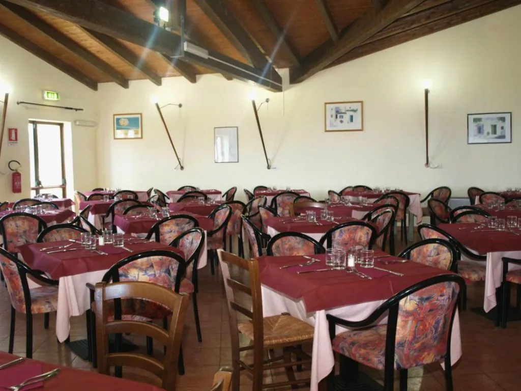 Sala ristorante interna con tavoli apparecchiati e soffitto in legno