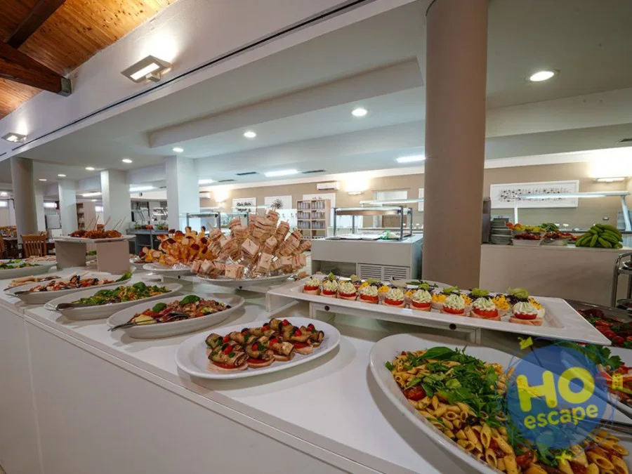 Ricco buffet con piatti di insalate, antipasti e finger food disposti nella sala ristorante