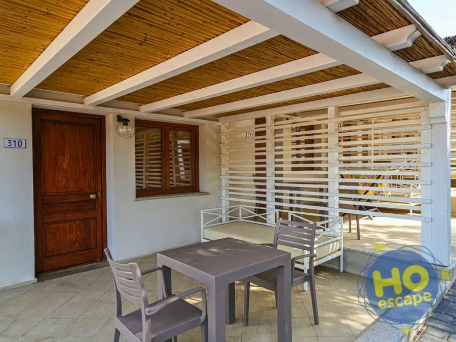 Patio coperto con pergolato in legno, tavolo e sedie all'ingresso della stanza 310