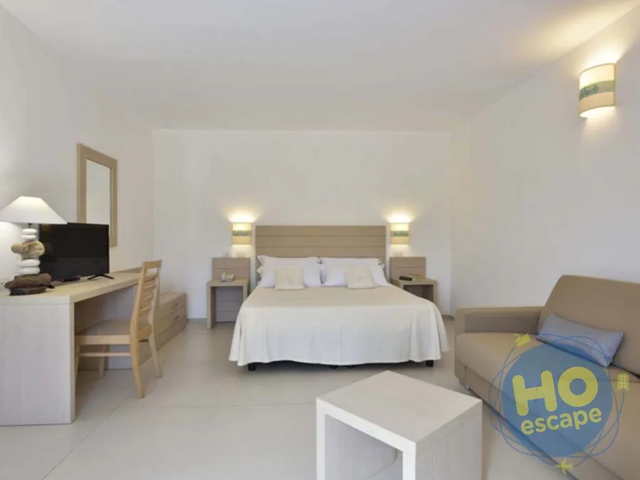 Camera spaziosa con letto matrimoniale, scrivania, divano e arredi chiari