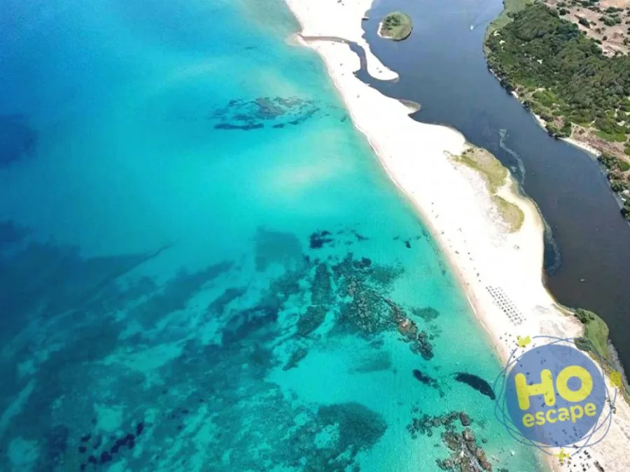 Veduta aerea della spiaggia con mare turchese cristallino e laguna in Sardegna