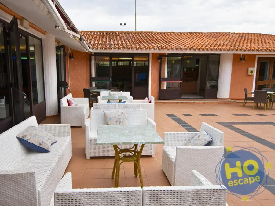 Terrazza esterna con divani in rattan bianco e tavolini