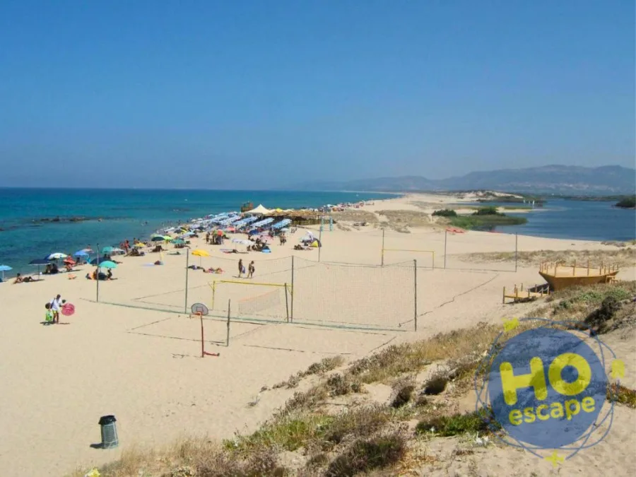 Ampia spiaggia con campi da beach volley, ombrelloni e laguna