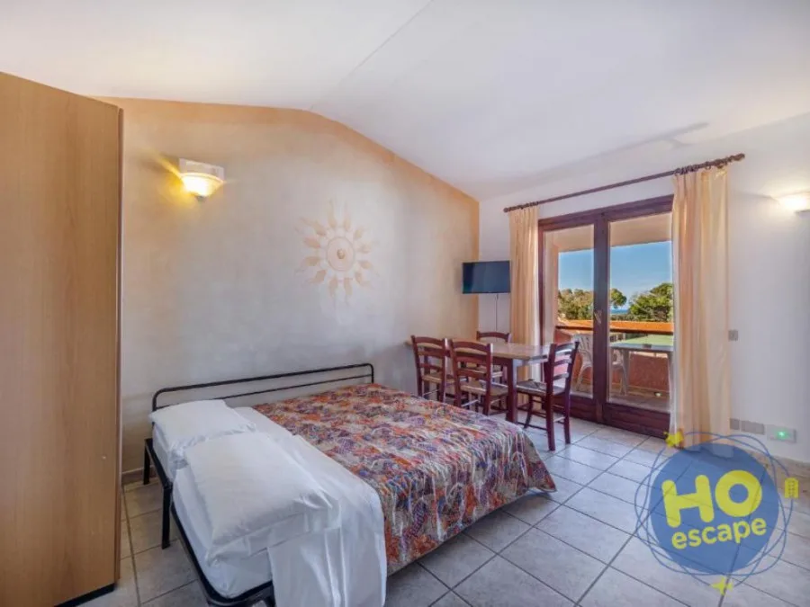 Camera con letto matrimoniale, tavolo da pranzo e balcone vista mare