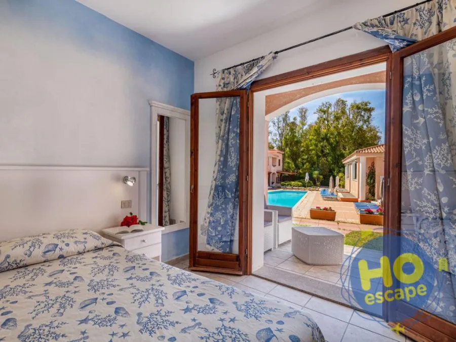Camera con letto a tema marino e porta finestra vista piscina