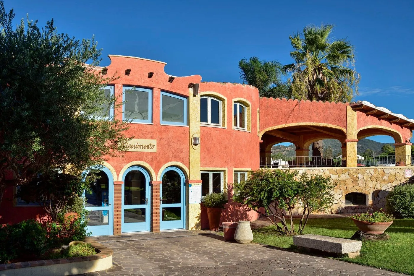 Edificio della reception del resort in stile mediterraneo con archi e giardino