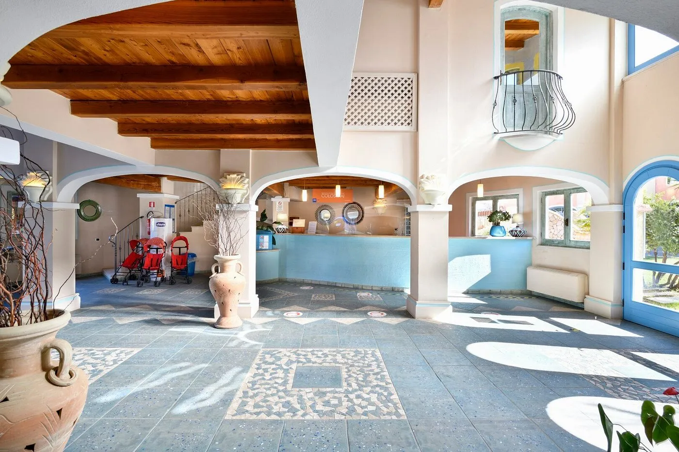 Hall del resort con soffitto in legno, archi e pavimento decorato a mosaico