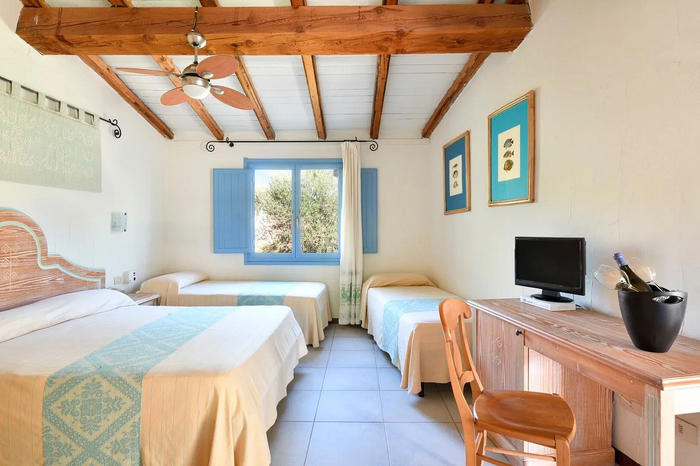 Camera tripla con soffitto in legno a vista e finestra con persiane azzurre