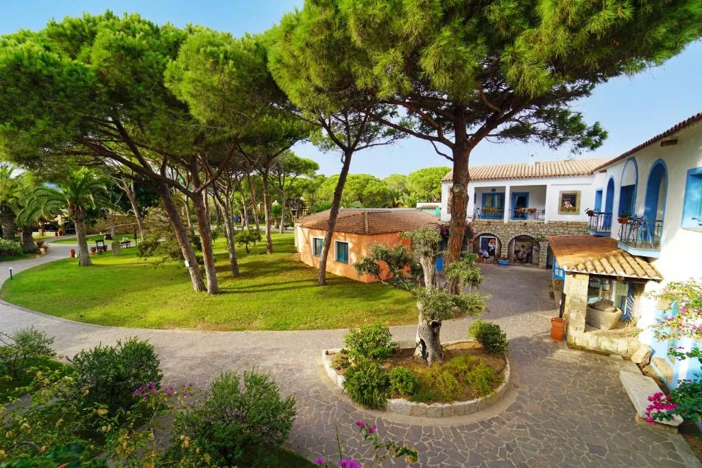 Vialetti e giardini curati tra gli edifici mediterranei del resort