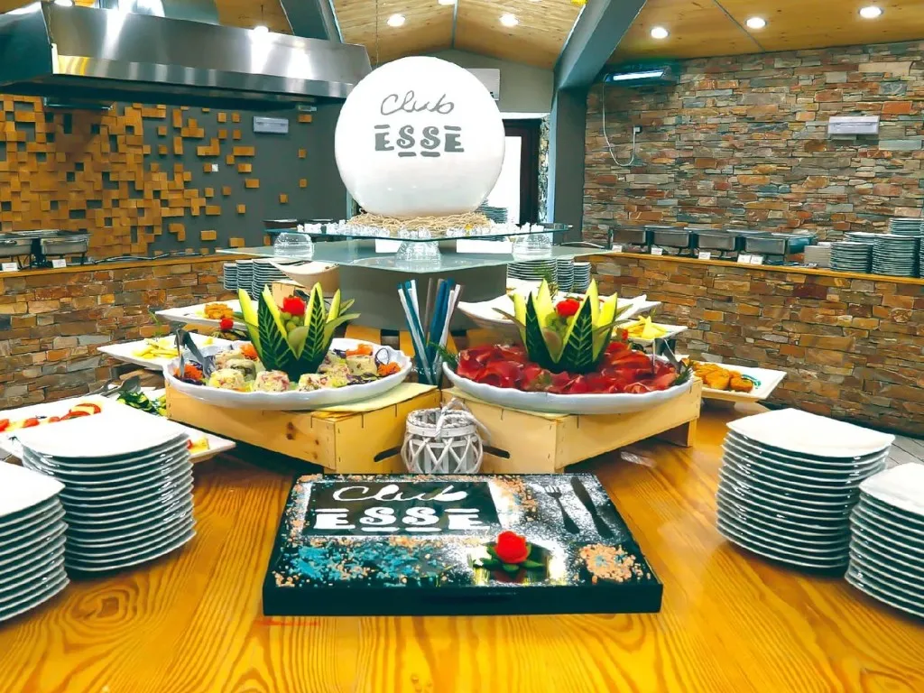Buffet del Club Esse con piatti curati e decorazioni di frutta e verdura