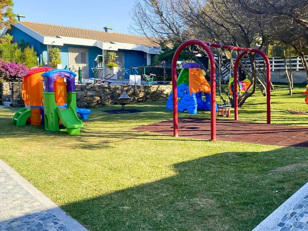 Parco giochi colorato per bambini con scivoli e altalene nel giardino