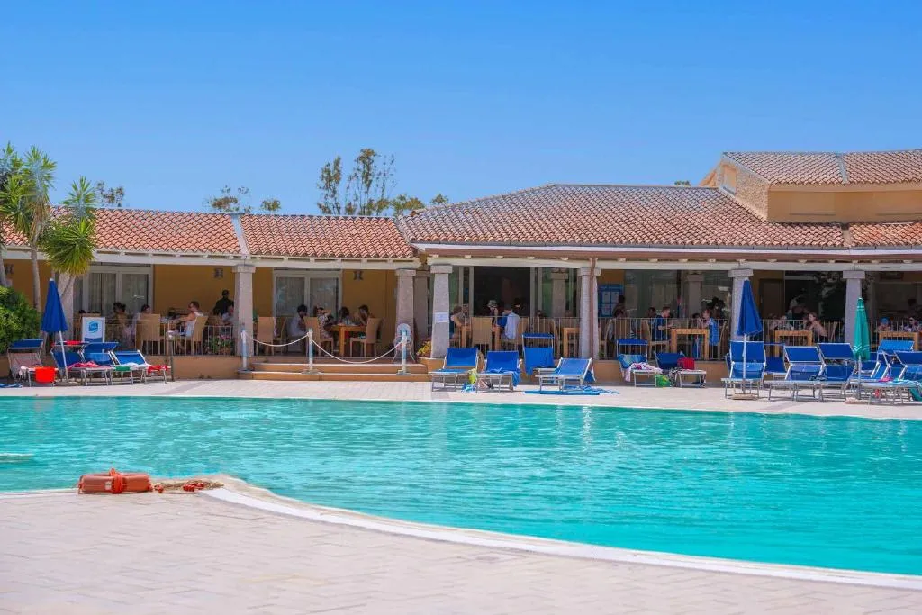 Piscina del resort con bar ristorante e ospiti sui lettini al sole