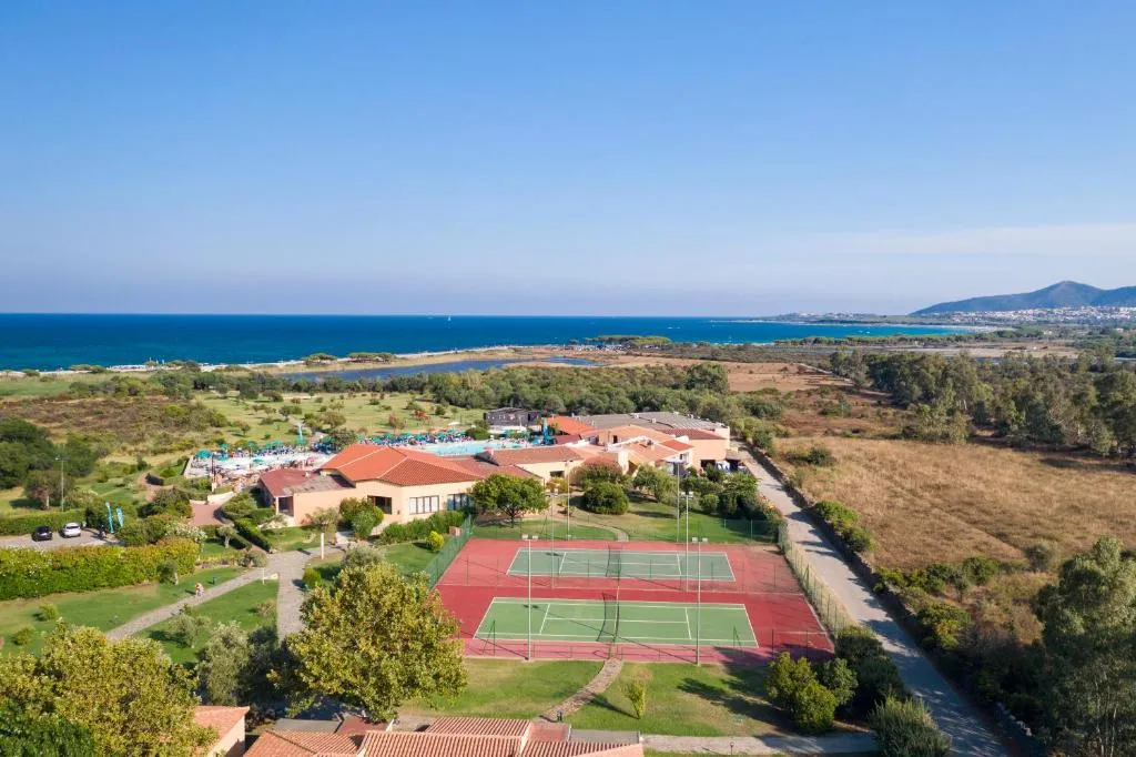 Veduta aerea del resort con campi da tennis, piscina e mare sullo sfondo
