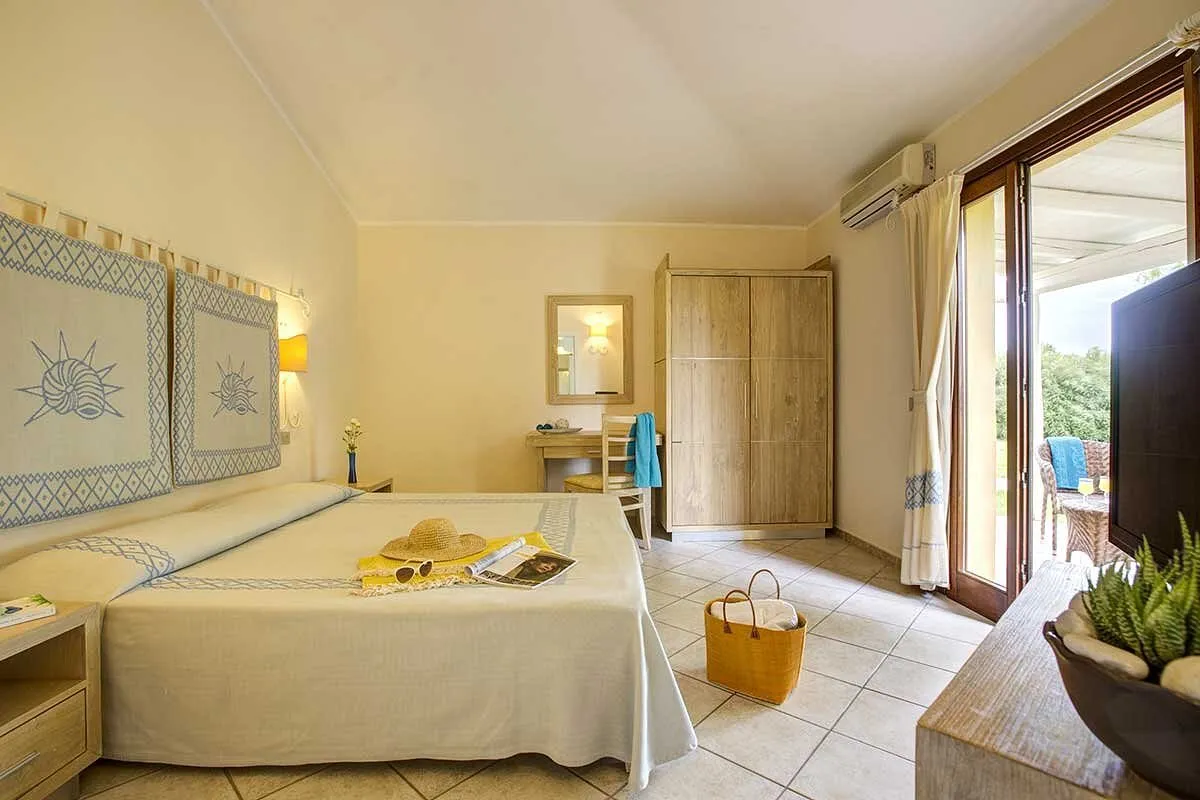 Camera da letto matrimoniale con armadio in legno e accesso al patio esterno