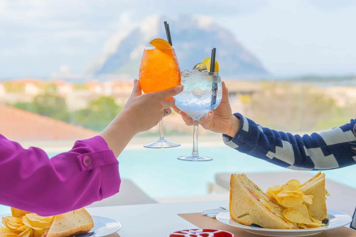Aperitivo con spritz e club sandwich vista Tavolara