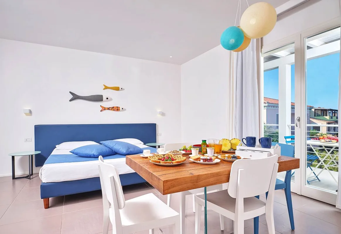 Camera con letto matrimoniale e colazione servita sul tavolo in legno