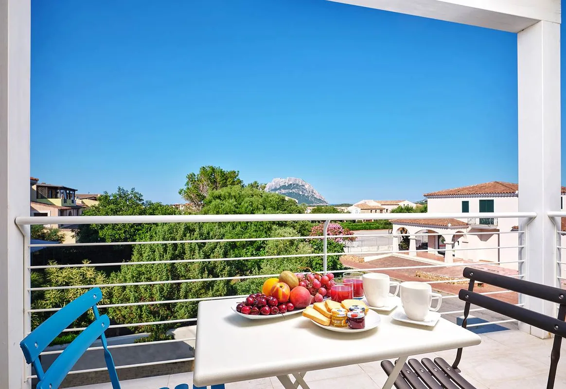 Balcone con tavolo e colazione a base di frutta e vista sull'Isola di Tavolara