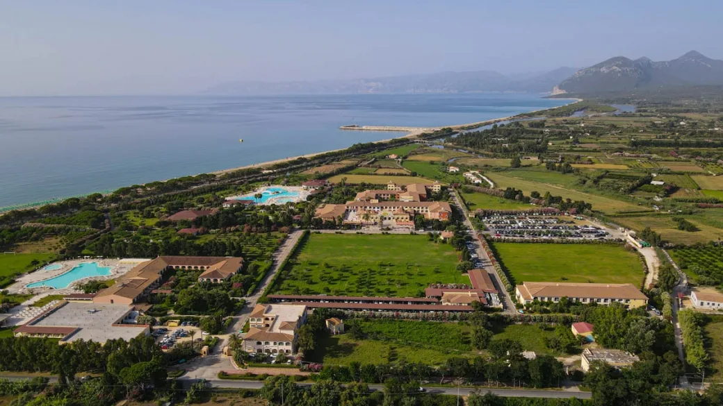 Vista aerea del resort immerso nel verde vicino al mare e alle montagne