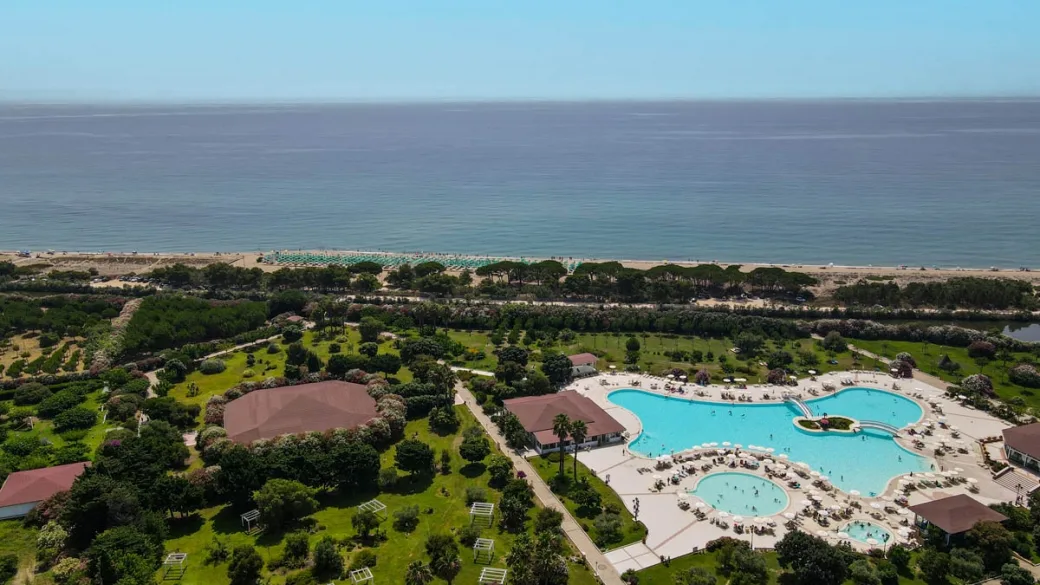 Piscina del resort immersa nel verde con vista sul mare