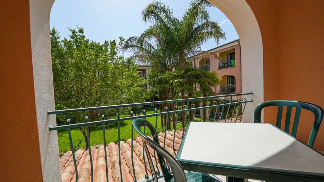 Balcone della camera con tavolino e sedie vista giardino