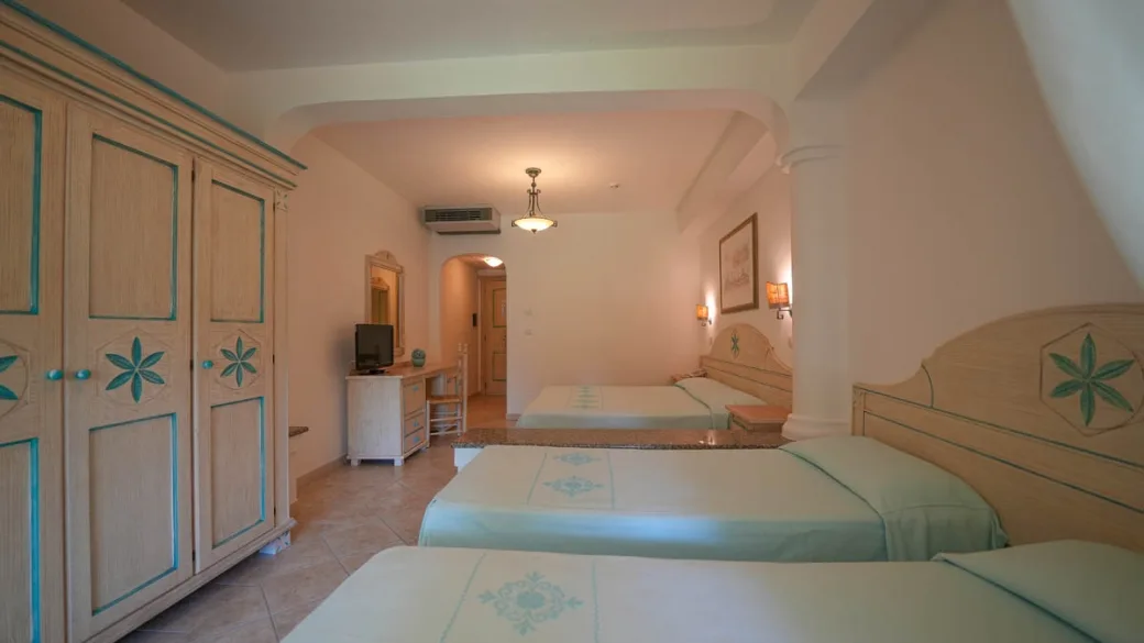Camera con letti, armadio decorato e TV in stile mediterraneo