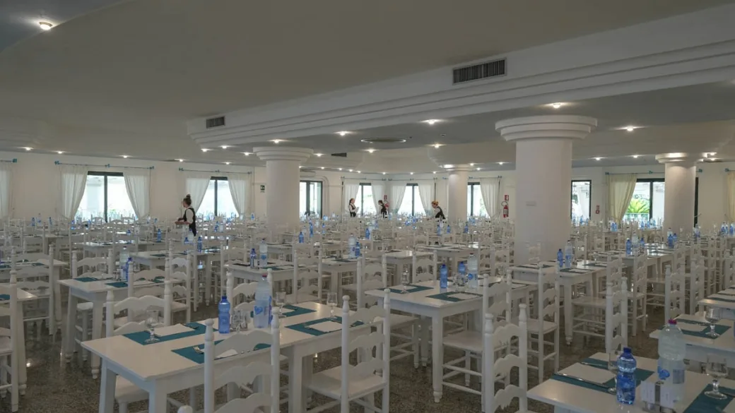 Ampia sala ristorante con tavoli bianchi e colonne