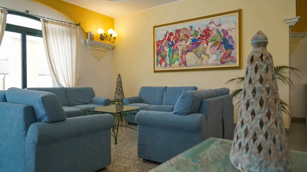 Salotto interno con divani azzurri e quadro decorativo