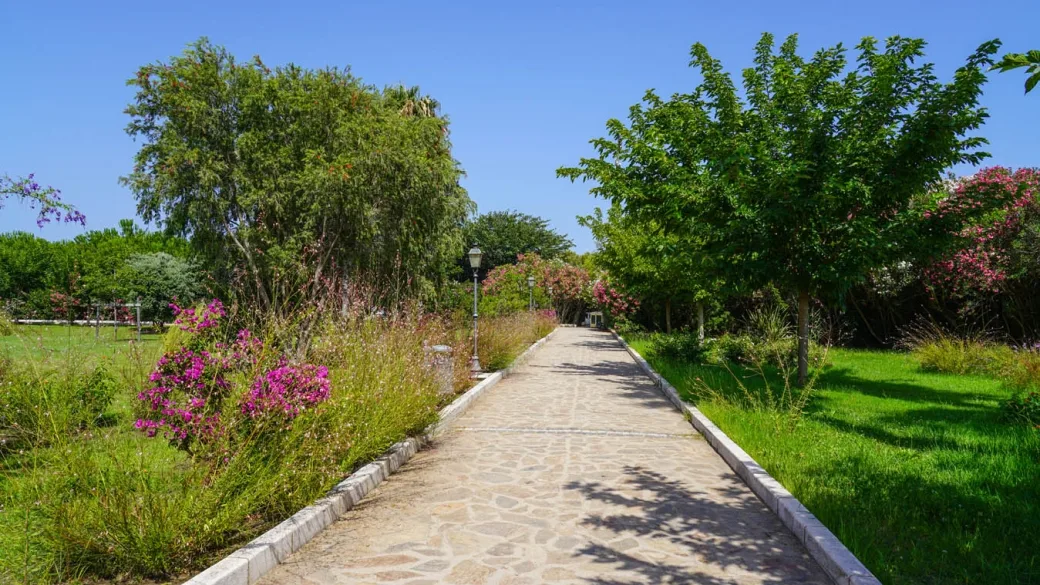 Vialetto in pietra circondato da giardini fioriti e alberi