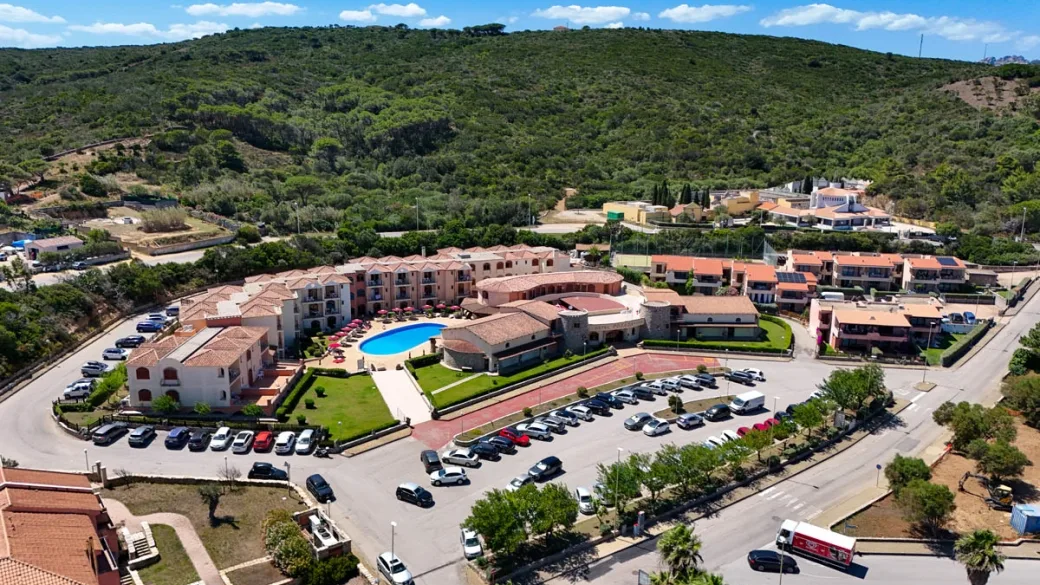Vista aerea del resort circondato dalla natura con piscina e parcheggio