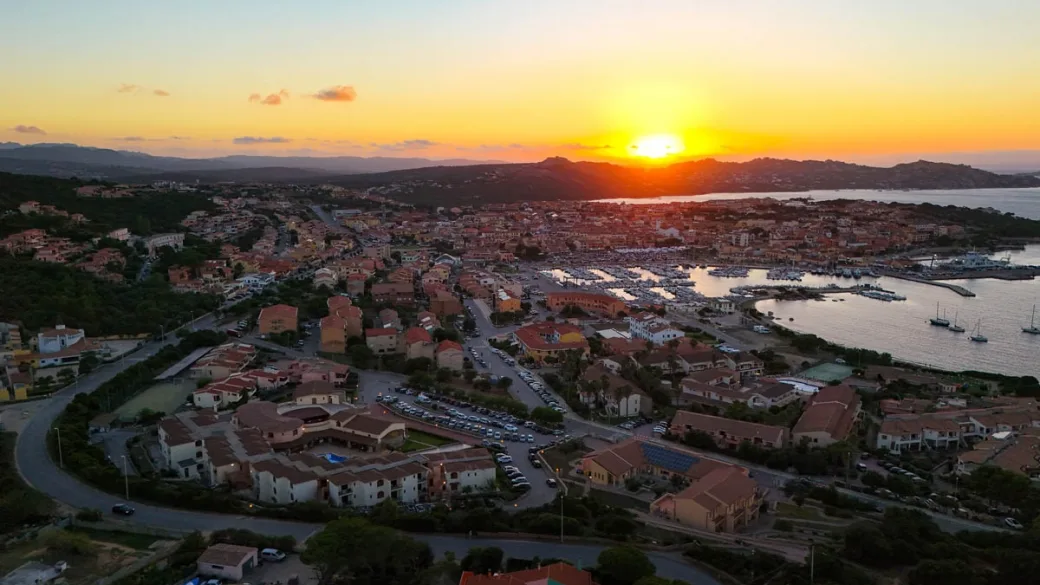 Tramonto panoramico sulla località costiera con porto e mare