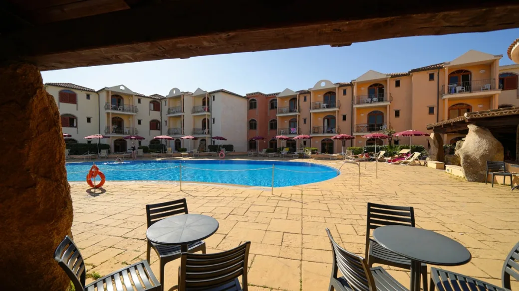 Piscina vista dalla terrazza coperta con tavolini e sedie