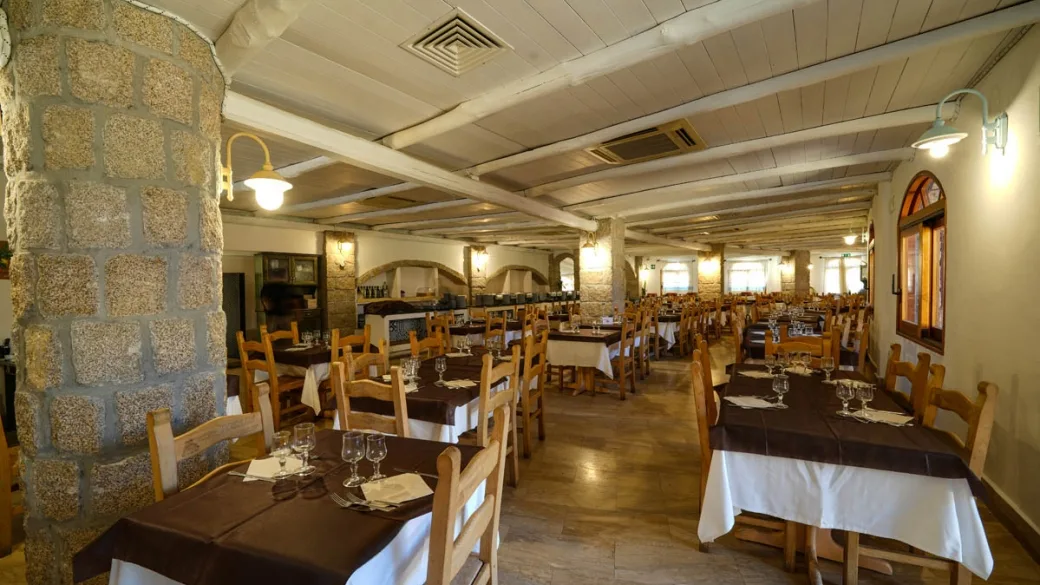 Sala ristorante interna con tavoli apparecchiati e colonne in pietra