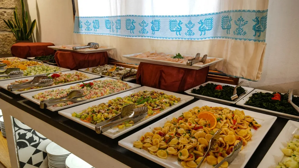 Buffet con piatti di pasta, insalate e verdure ben presentati