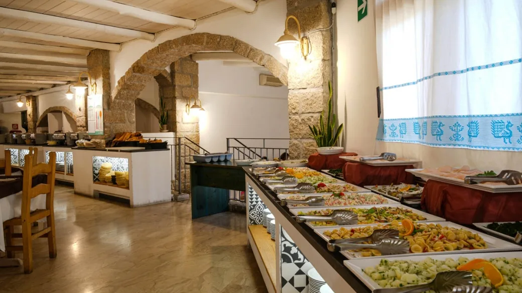 Buffet del ristorante con ampia scelta di pietanze e archi in pietra