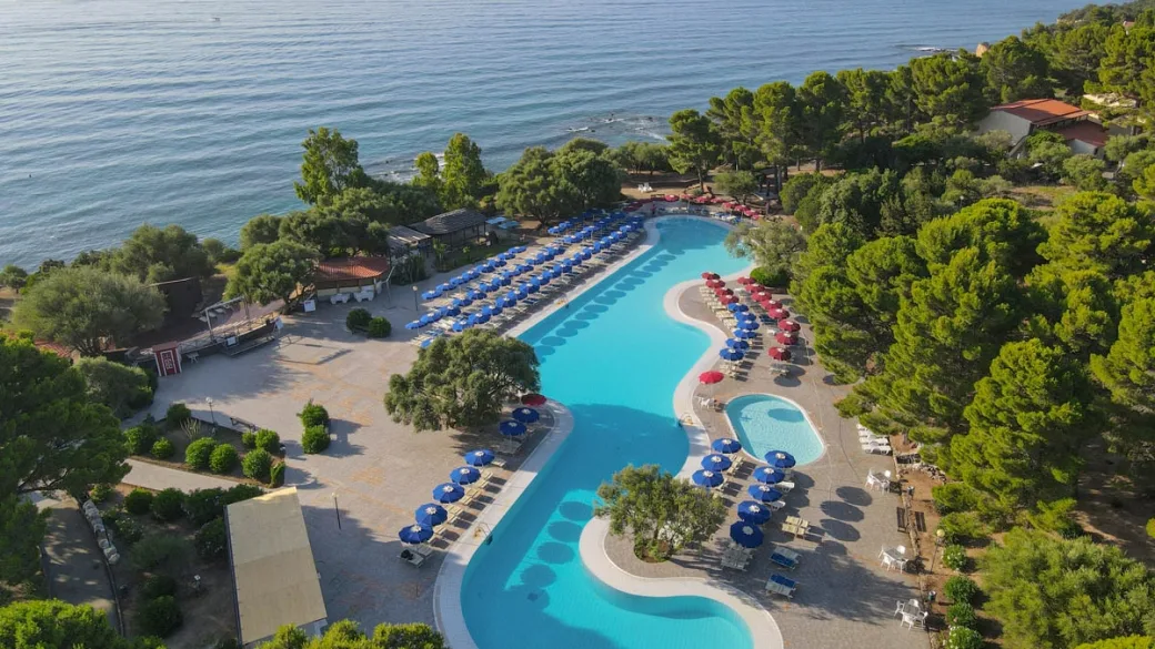 Piscina a forma irregolare con ombrelloni vista mare