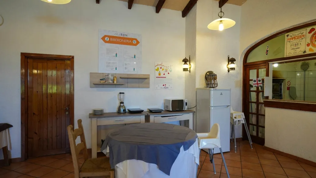 Sala biberoneria attrezzata con cucina, microonde e seggioloni per bambini