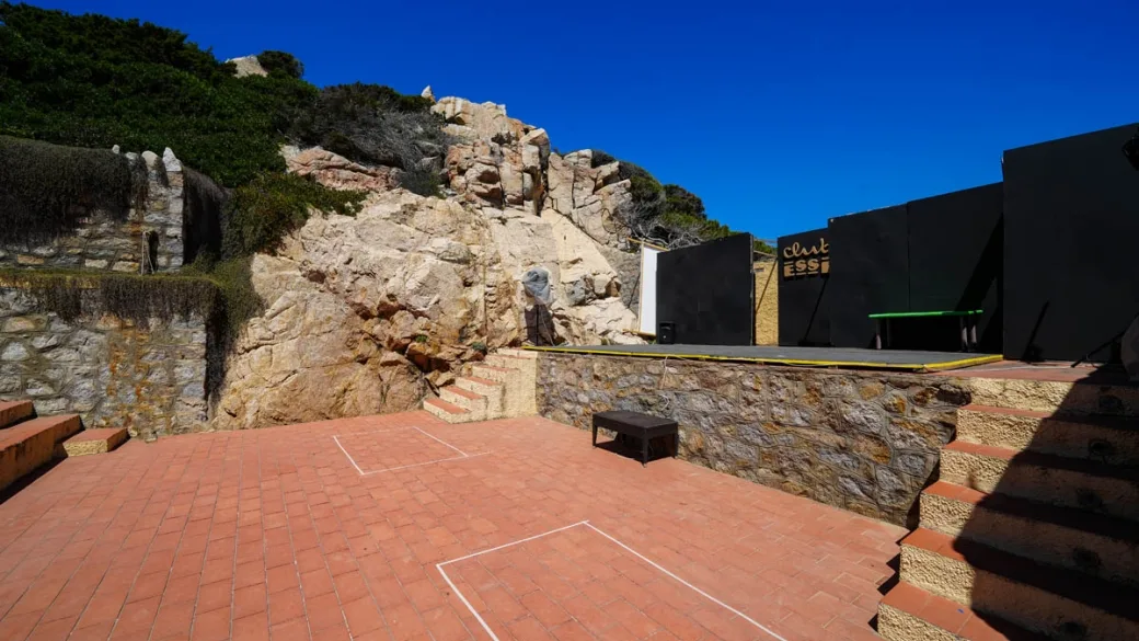 Terrazza pavimentata con palco e scenografia tra le rocce di granito