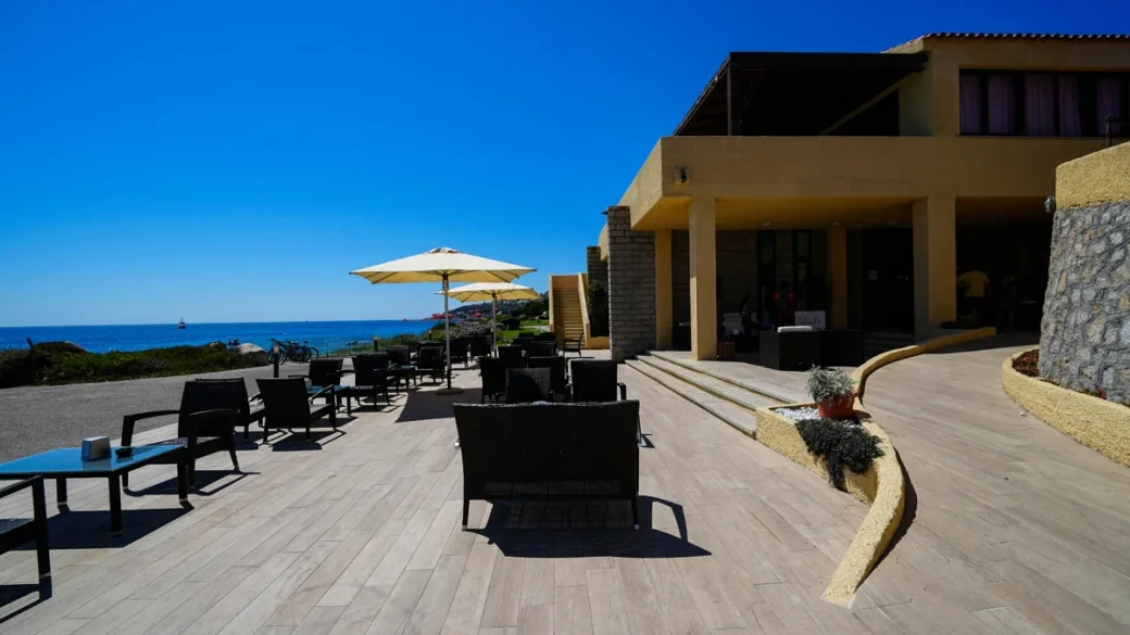 Terrazza esterna del ristorante con tavoli, ombrelloni e vista sul mare