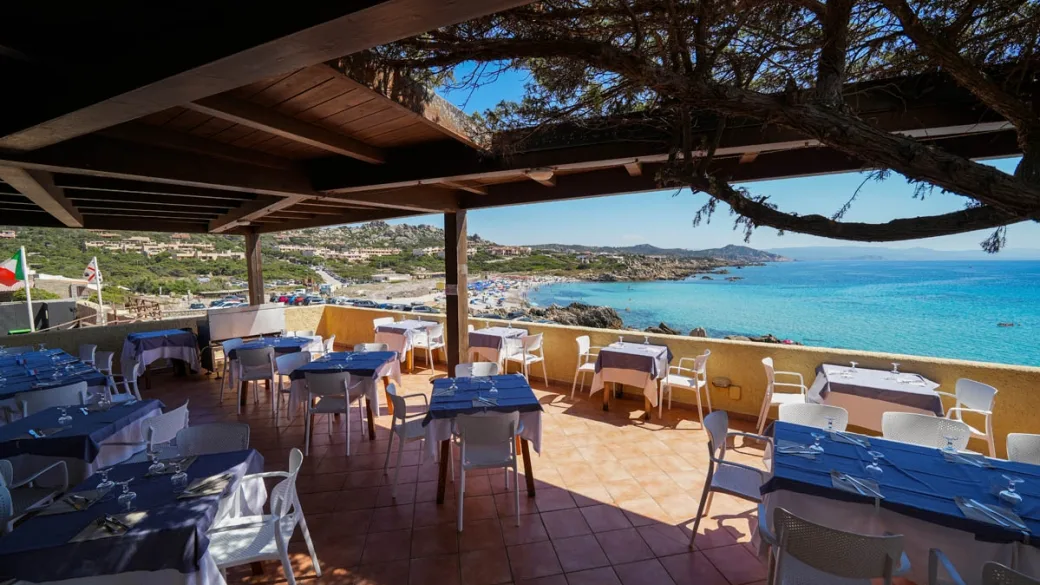 Terrazza panoramica del ristorante con tavoli vista mare e spiaggia